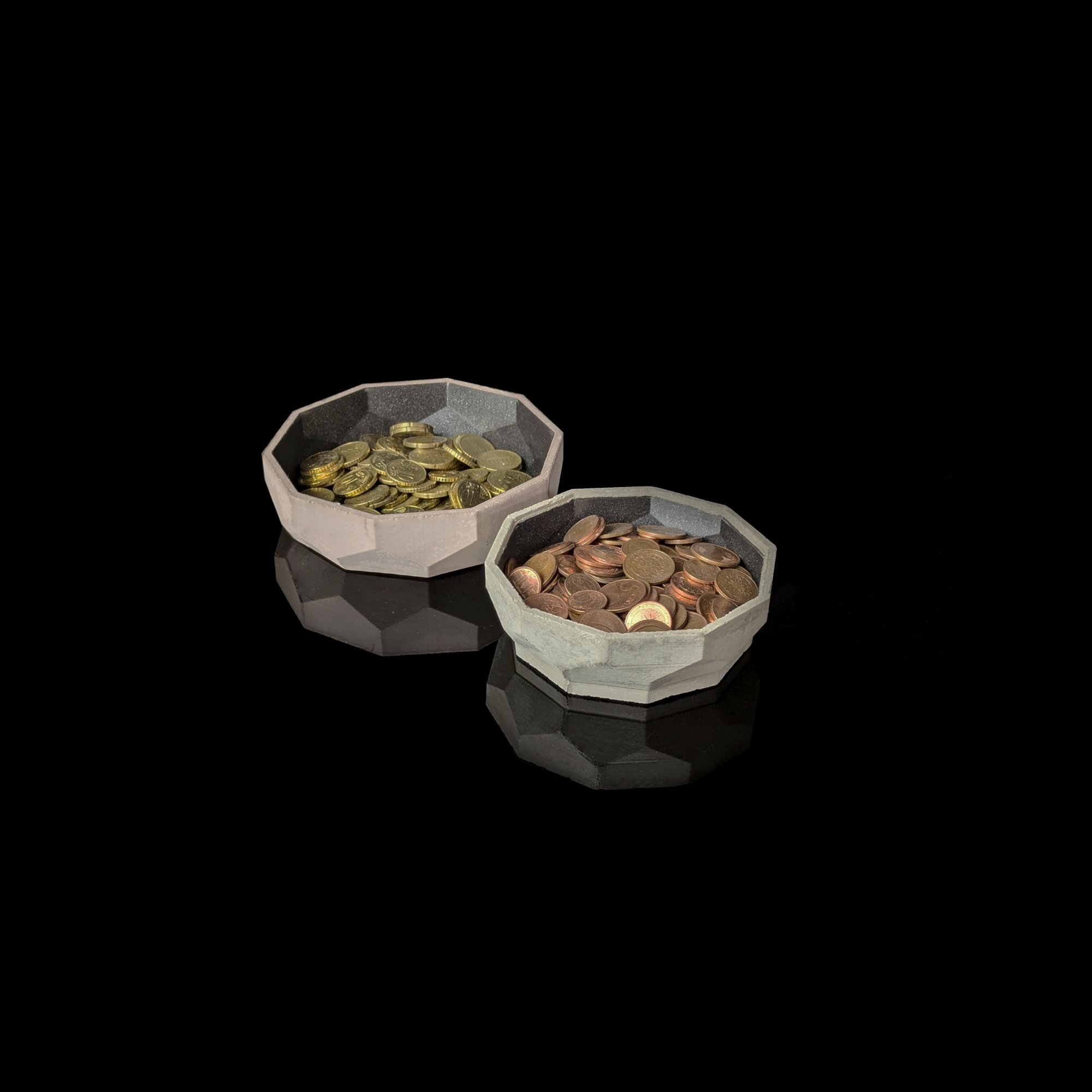 Two concrete bowls with coins, placed on a black background. The link leads to the subpage 'Concrete'.